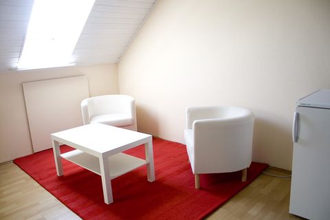Zimmer 1: moderne Sitzecke mit zwei Sesseln, Tisch und Kühlschrank