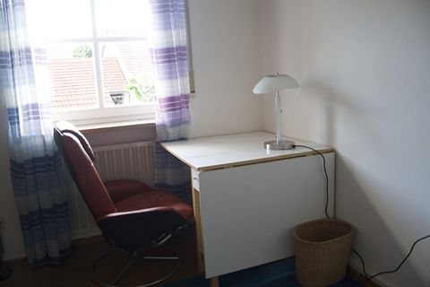 Zimmer 2: Schreibtisch mit Bürostuhl und Tischlampe am Fenster